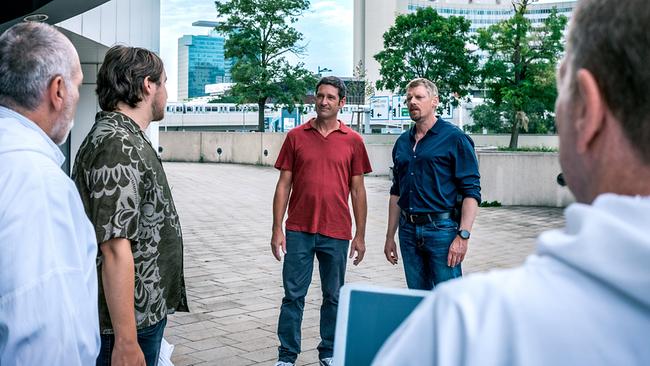 Julius Rubatsch, Klaus Lechner, Max Herzog und zwei weitere Forensiker stehen vor einem großen Verwaltungsgebäude und unterhalten sich.