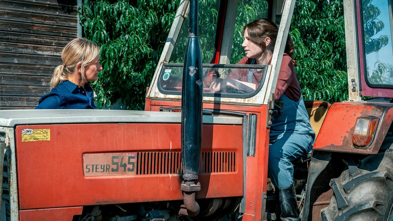 Angelika Niedetzky spricht mit Anna Rieser, die in einem Traktor sitzt.