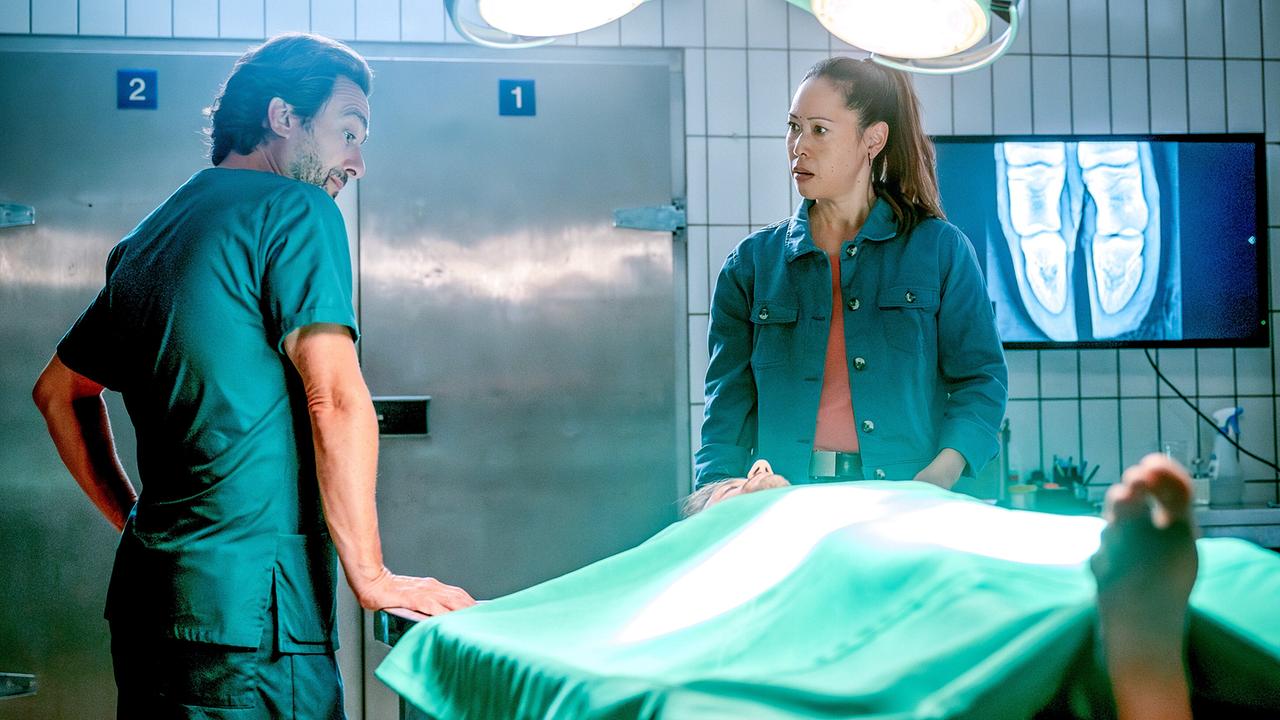 Alexander Pschill und Miriam Hie stehen bei einer Leiche im Obduktionsraum.