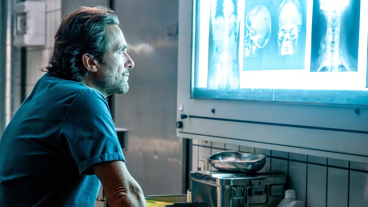 Alexander Pschill betrachtet Röntgenaufnahmen des Toten an einer Leuchtwand.