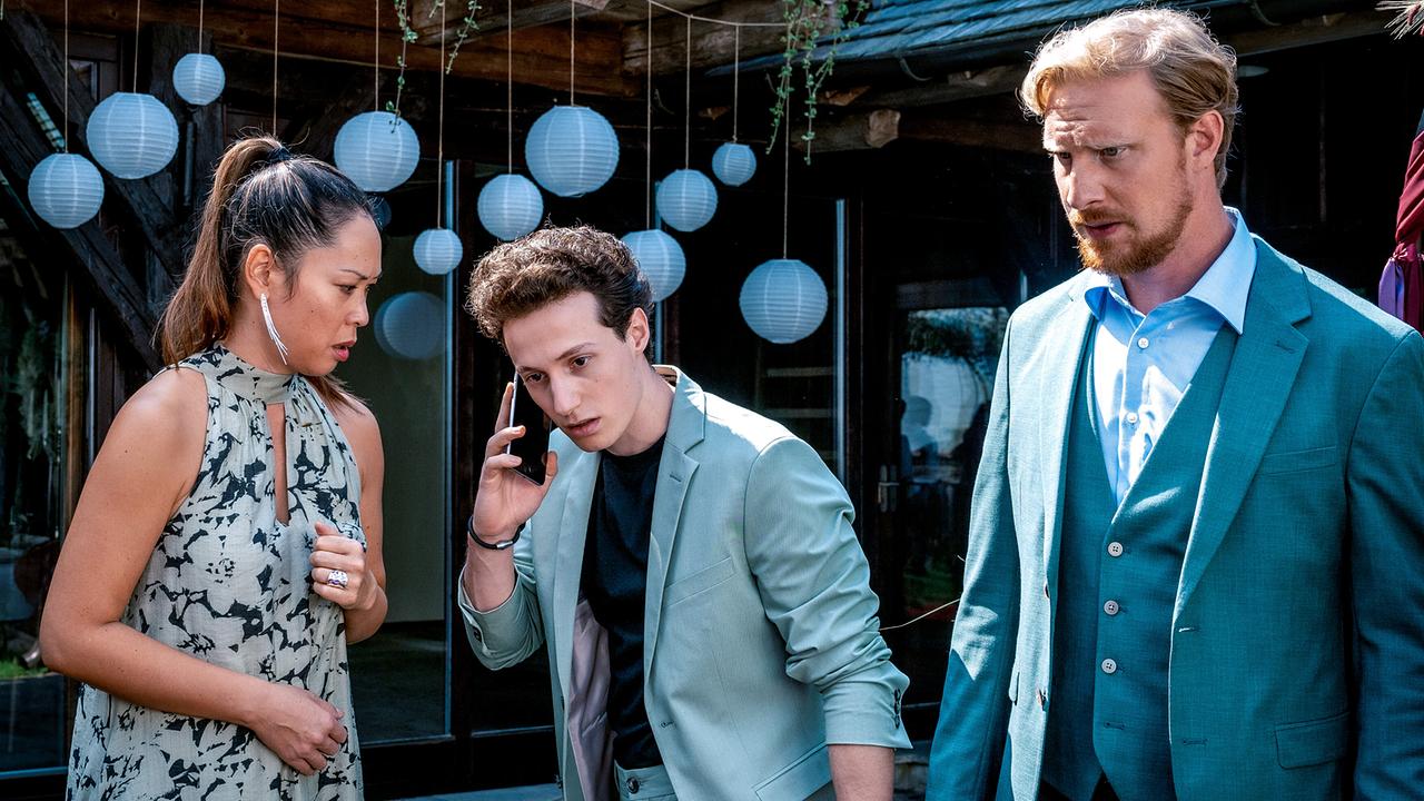 Miriam Hie, Damyan Andreev und Michael Edlinger sind festlich gekleidet und stehen zusammen, während Damyan Andreev telefoniert.