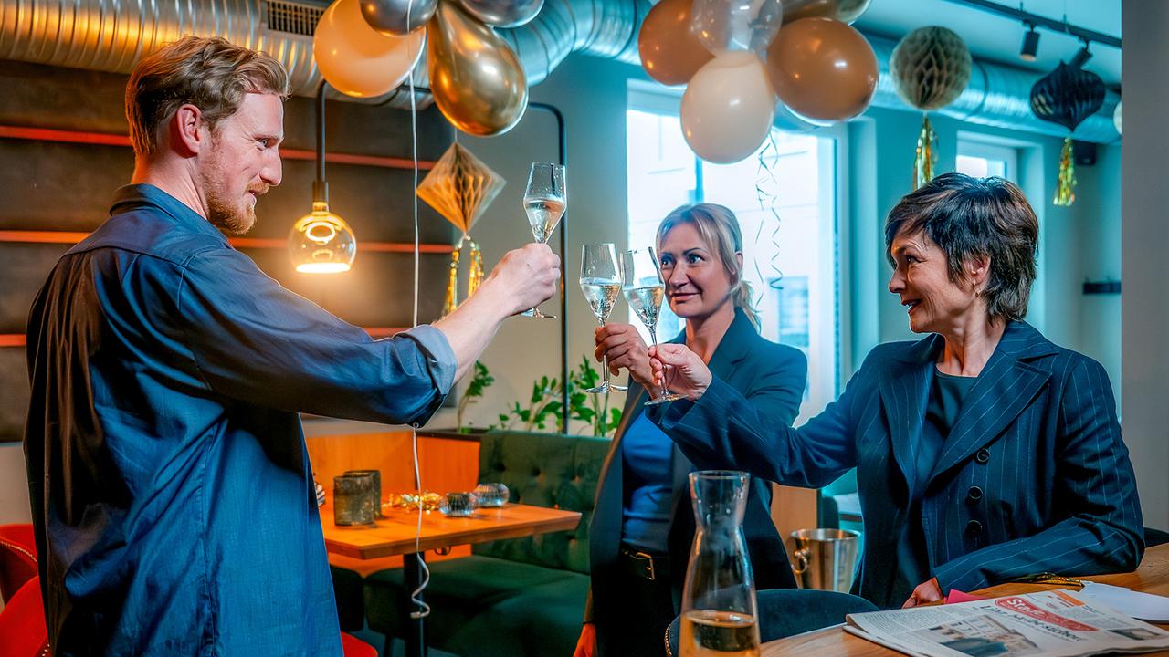 © ORF/Gebhardt Productions/Stefanie Leo Walter Obergschwendter, Biggi Obergschwendter und Joe Haizinger stoßen in einem mit Luftballons dekoriertem Lokal mit Sektgläsern an.