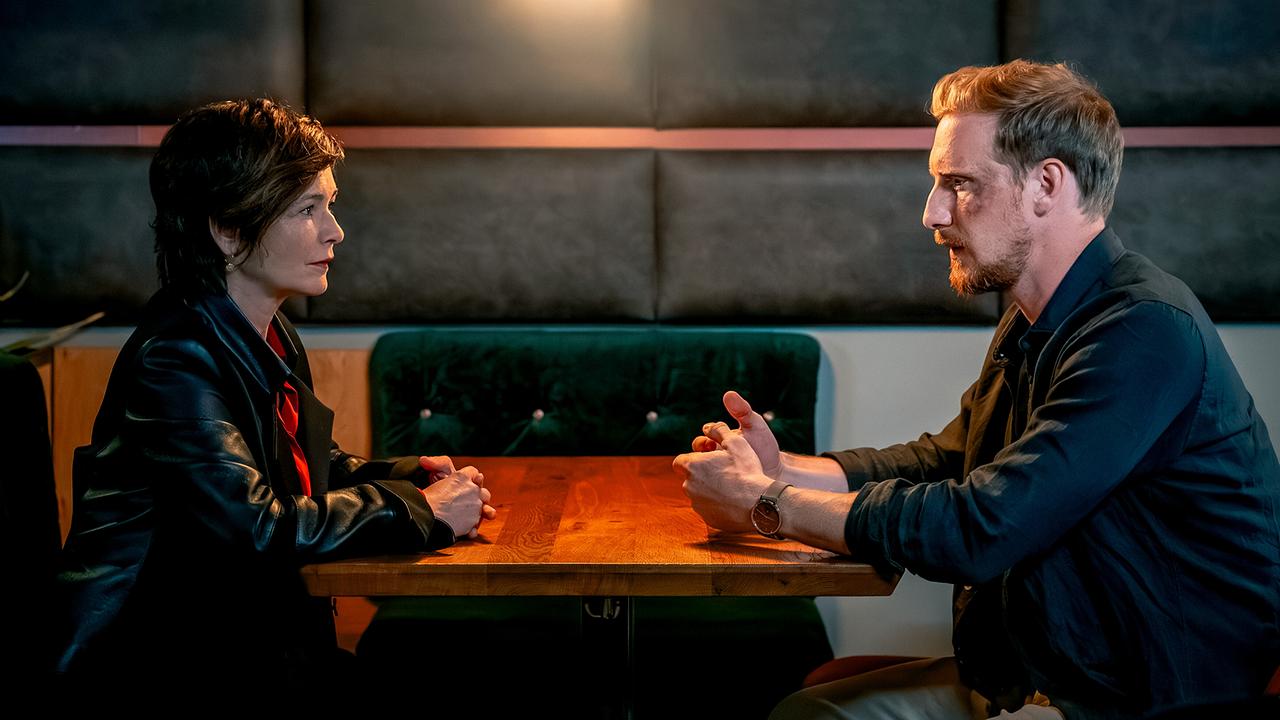 © ORF/Gebhardt Productions/Stefanie Leo Joe Haizinger und Walter Obergschwendter sitzen sich abends in einem Lokal ernst gegenüber.