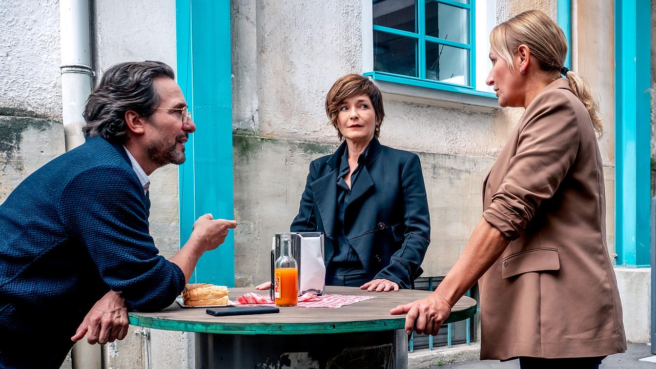 Dr. Richie Vitek, Joe Haizinger und Biggi Obergschwendter besprechen sich an einem improvisierten Stehtisch in einem Innenhof.