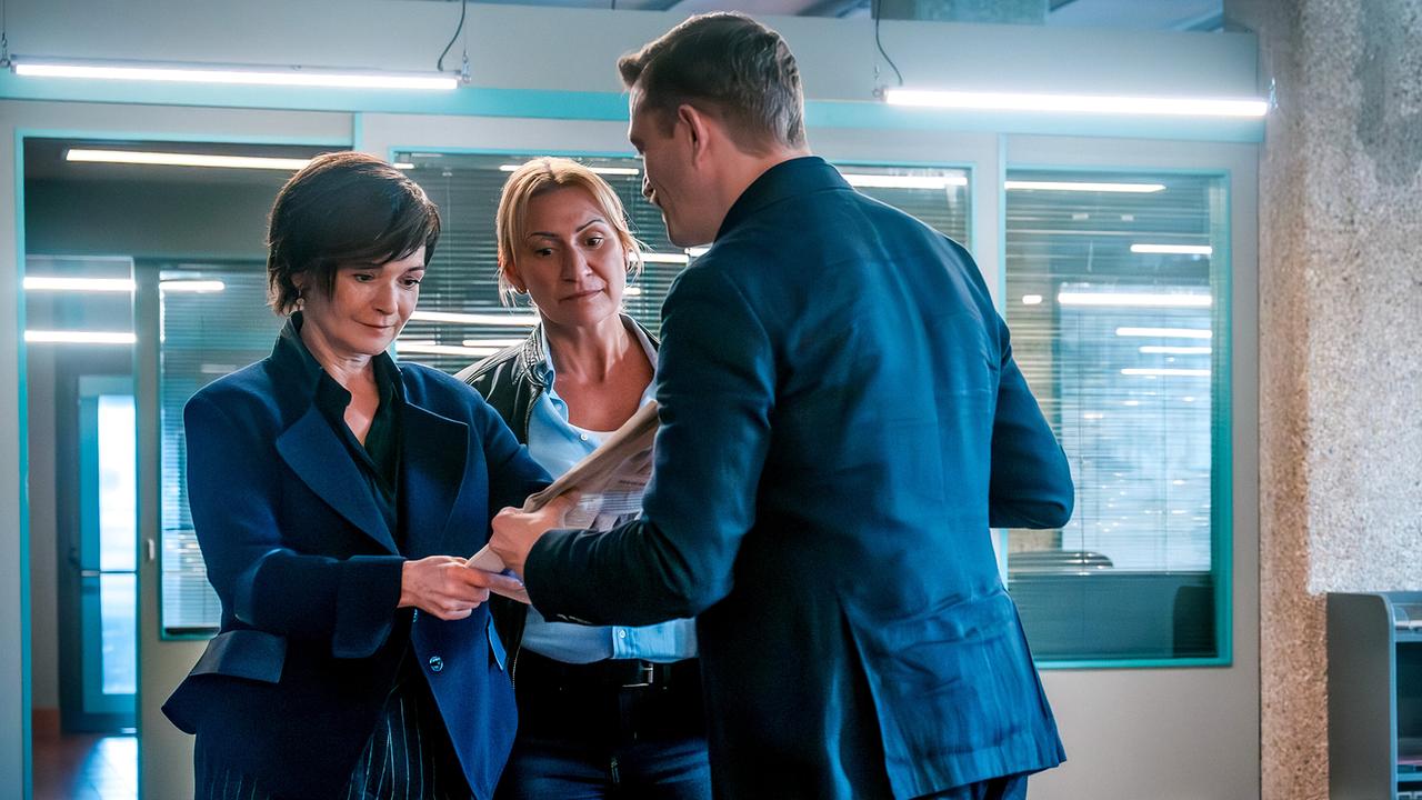 © ORF/Gebhardt Productions/Stefanie Leo Stefan Pichlwanger zeigt im Büro Joe Haizinger und Biggi Obergschwendter etwas in einer Zeitung.