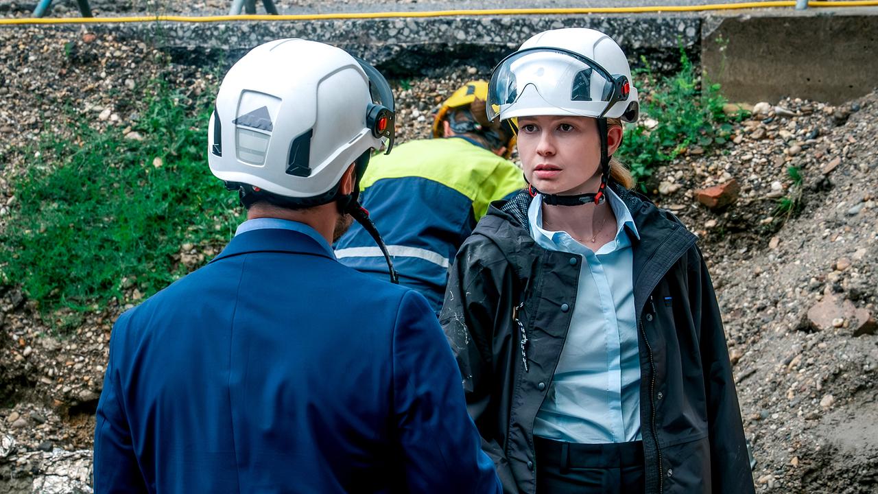 © ORF/Gebhardt Productions/Stefanie Leo Bauprojektleiterin Lisa Scharnick mit Schutzhelm steht auf einer Baustelle im Gespräch mit Pirmin Zissner.