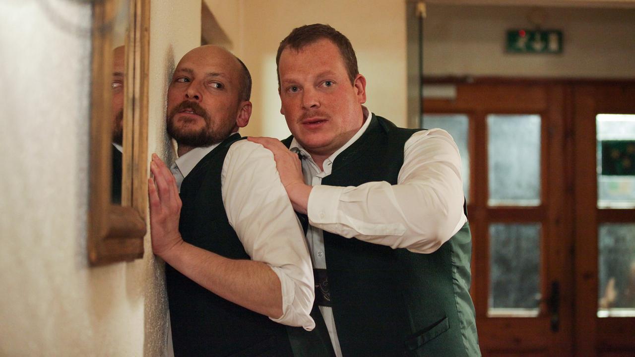 Ferdinand Franz drückt Zlatko in einem Flur an die Wand.