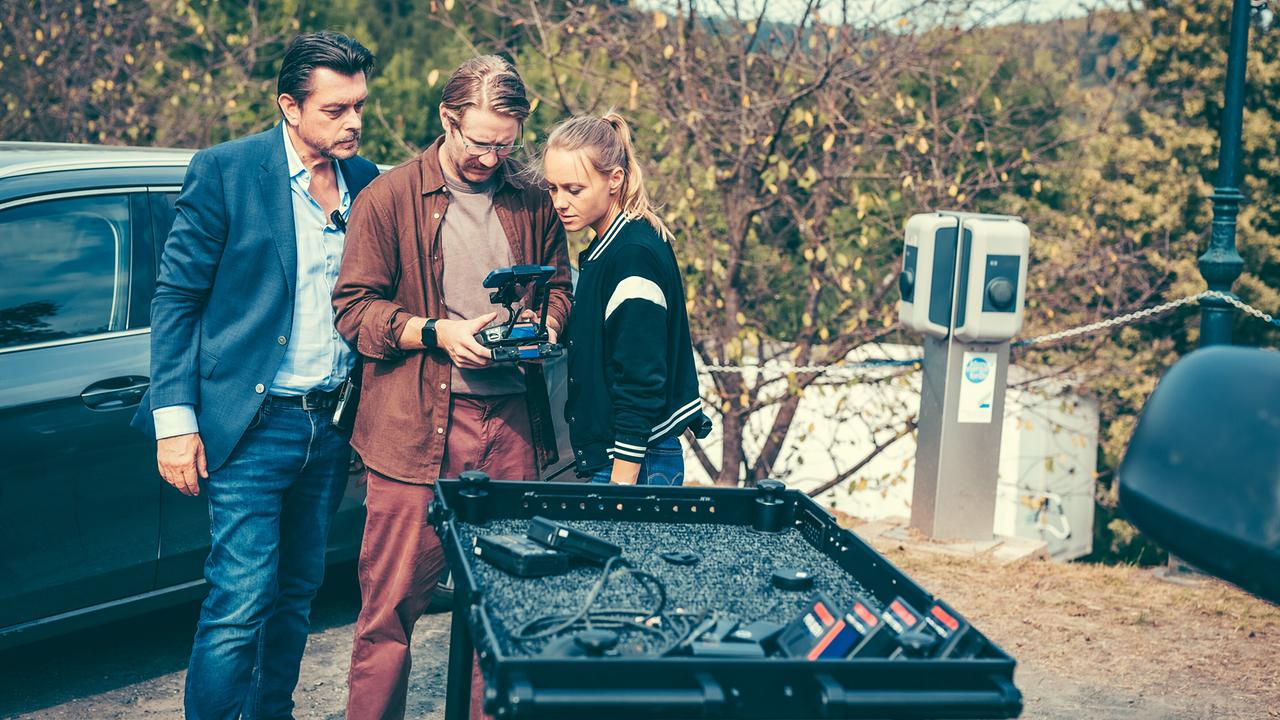 Christoph Kohlbacher bedient im Freien eine Fernsteuerung, Hary Prinz und Anna Unterberger schauen ihm über die Schulter - vor ihnen ein Koffer mit Ausrüstung.