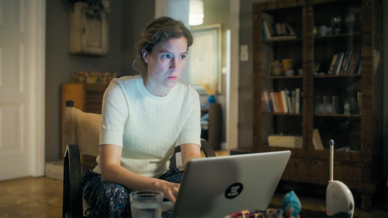 © ORF/MR Film Franziska Hackl arbeitet an einem Laptop in einem Wohnzimmer mit Bücherregal