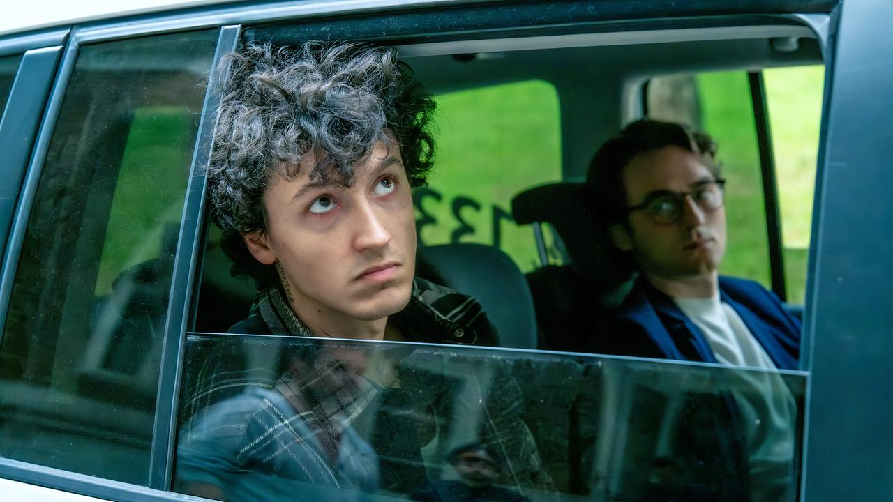 © ORF/MR Film/Christopher Glanzl Etienne Halsdorf sitzt im Fond eines Autos und blickt aus dem geöffneten Fenster., neben ihm sitzt Tobias Resch.