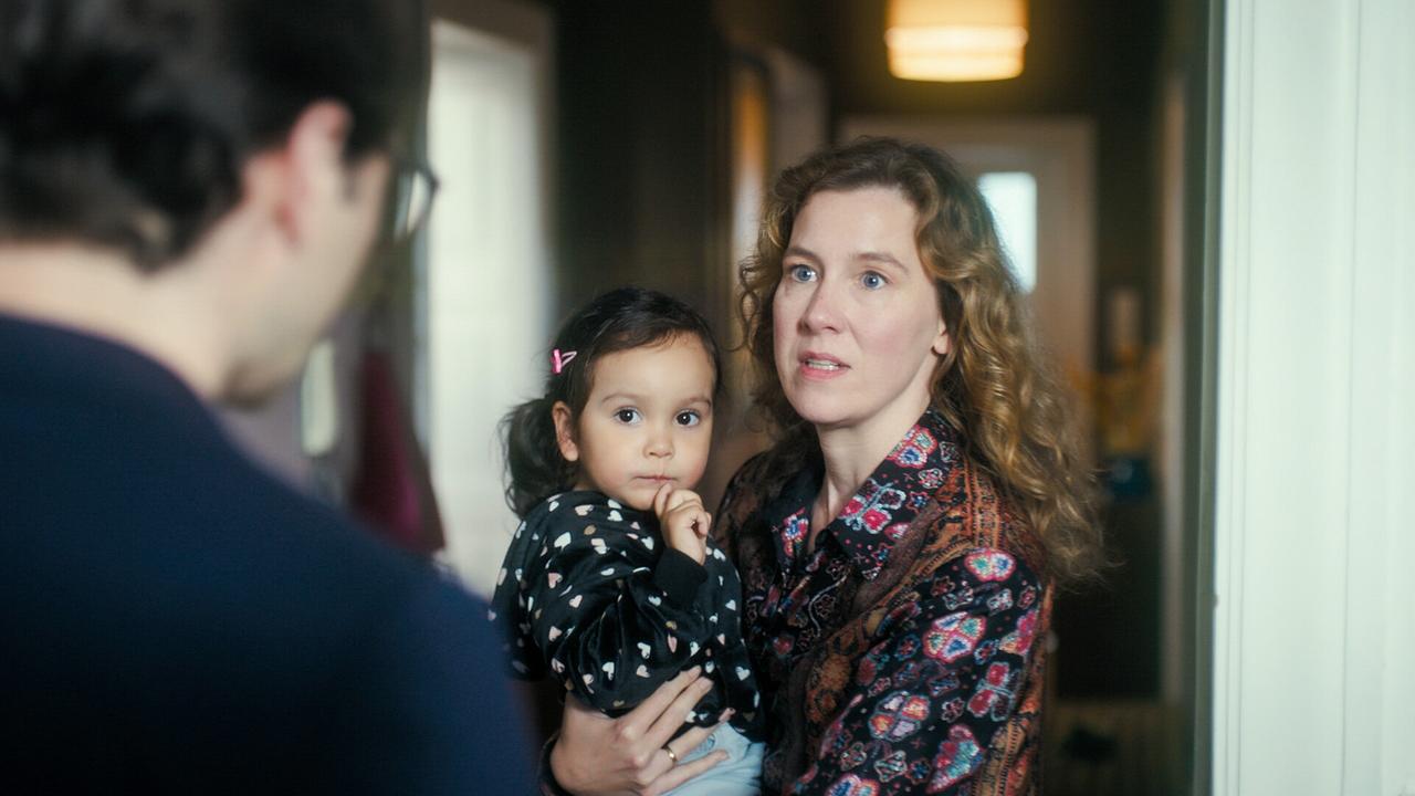 © ORF/MR Film Franziska Hackl hält ein kleines Kind im Arm und spricht mit Tobias Resch im Flur.