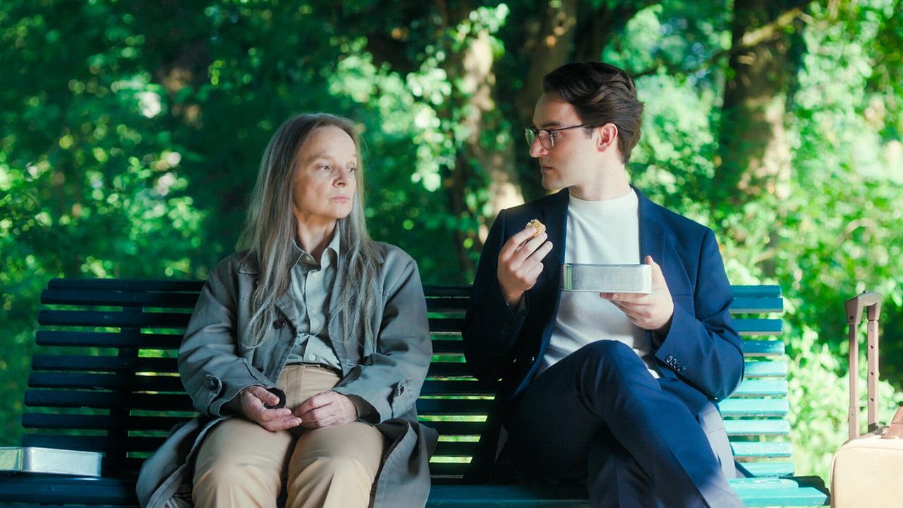© ORF/MR Film Sissy Höfferer und Tobias Resch sitzen auf einer Parkbank im Grünen und essen gemeinsam aus einer Dose.