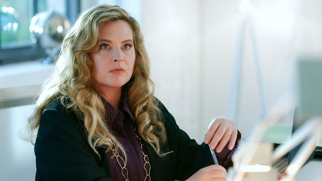 © ORF/MR Film/Petro Domenigg Diana Amft sitzt am Schreibtisch in einem hellen Raum und hält einen Stift in der Hand.