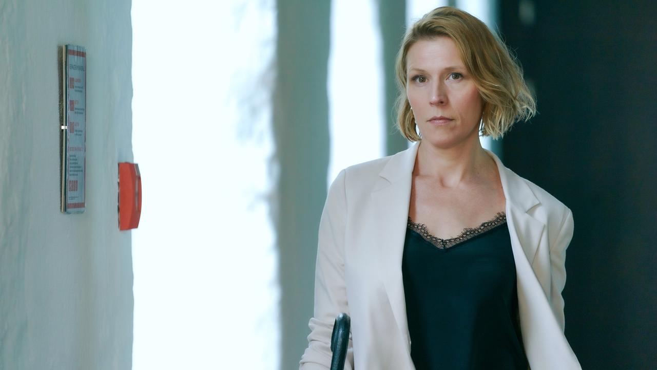 © ORF/MR Film/Petro Domenigg Franziska Weisz im hellen Blazer und schwarzem Top geht durch einen Flur.