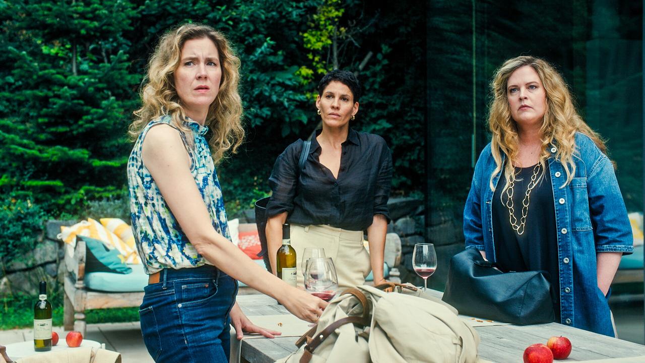 Franziska Hackl, Jasmin Gerat und Diana Amft  stehen an einem Gartentisch mit Getränken und Äpfeln, im Hintergrund eine Sitzecke im Freien.