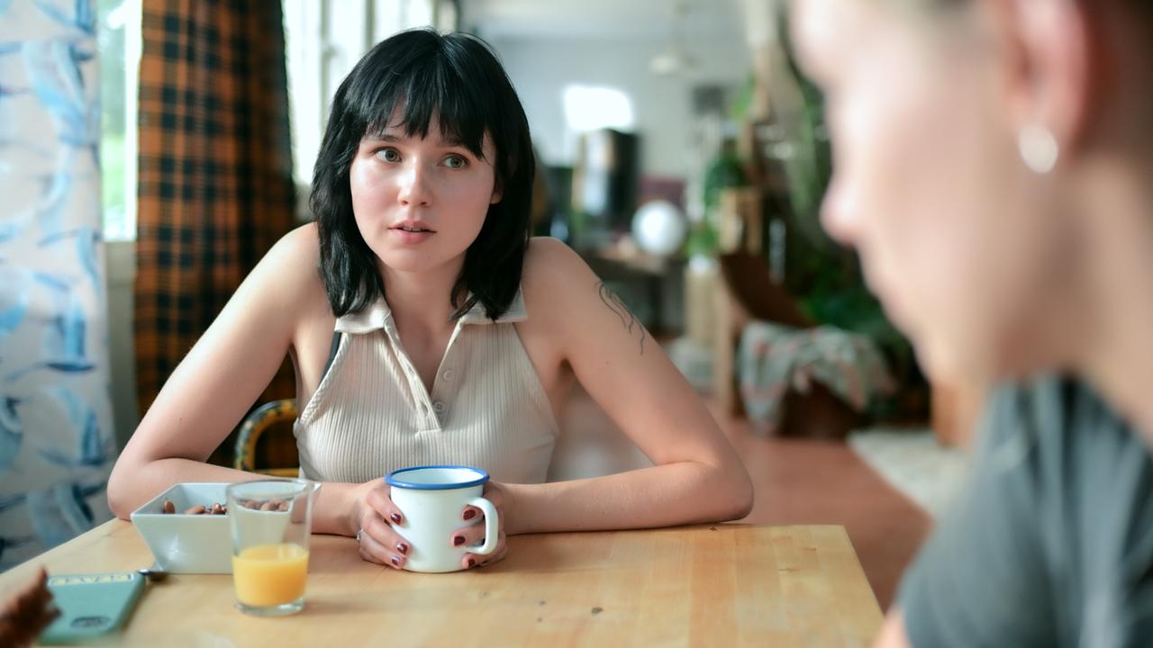 © ORF/MR Film/Christopher Glanzl Paulina Hobratschk sitzt am Esstisch mit einer Tasse Kaffee, einem Glas Orangensaft und einer Schüssel mit Müsli vor sich und blickt eine weitere Person am Tisch an.