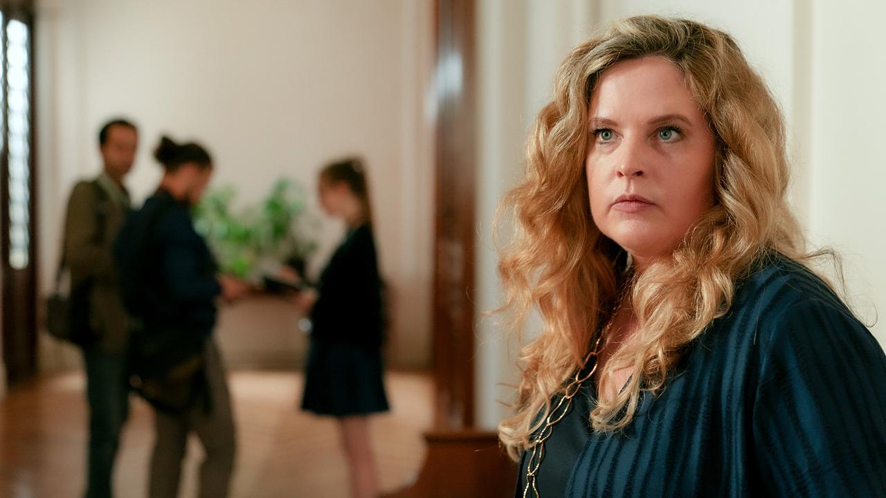 © ORF/MR Film/Petro Domenigg Diana Amft steht im Vordergrund eines hellen Flurs, während im Hintergrund drei Personen miteinander sprechen.