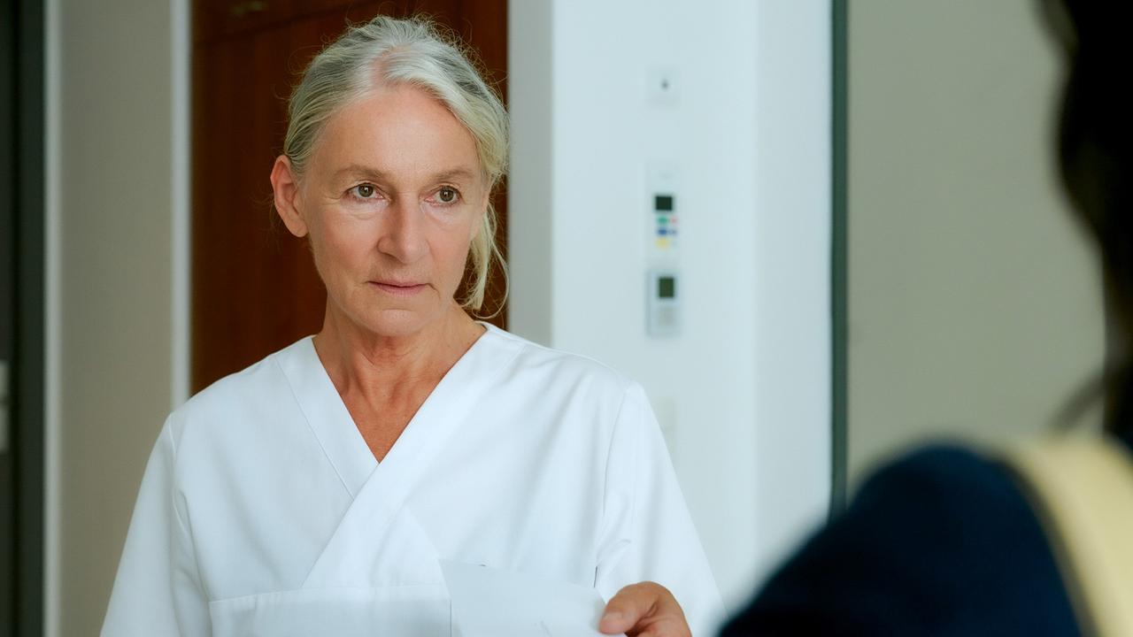 © ORF/MR Film/Petro Domenigg Eine Krankenschwester in weißer Uniform reicht Paulina Hobratschk ein Dokument.
