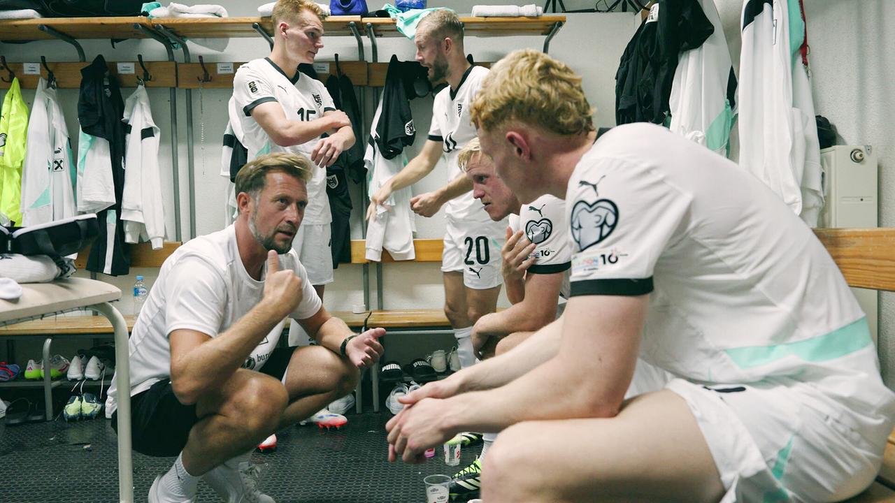 Assistenz-Trainer Lars Kornetka im Hocken spricht mit Philipp Lienhart, Konrad Laimer, Xaver Schlager und Nicolas Seiwald in der Umkleidekabine