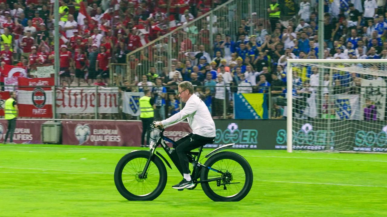 Teamchef Ralf Rangnick lässt es sich nicht nehmen, trotz körperlicher Beeinträchtigung, das Team zu führen und fährt mit dem E-Bike durch das Stadion und das Trainingsgelände.