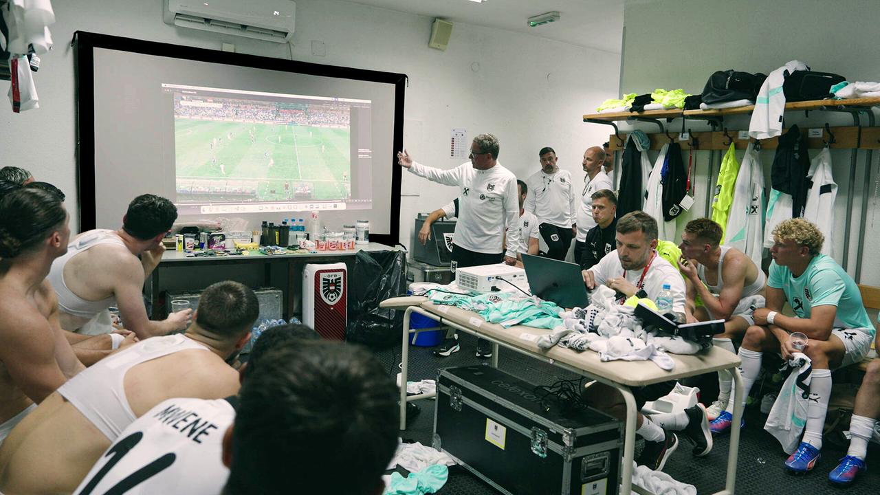 Pausenanalyse mit Teamchef Ralf Rangnick und dem Team in der Kabine beim Spiel gegen Bosnien. Die Spielszenen werden auf eine Leinwand in der Kabine projiziert.