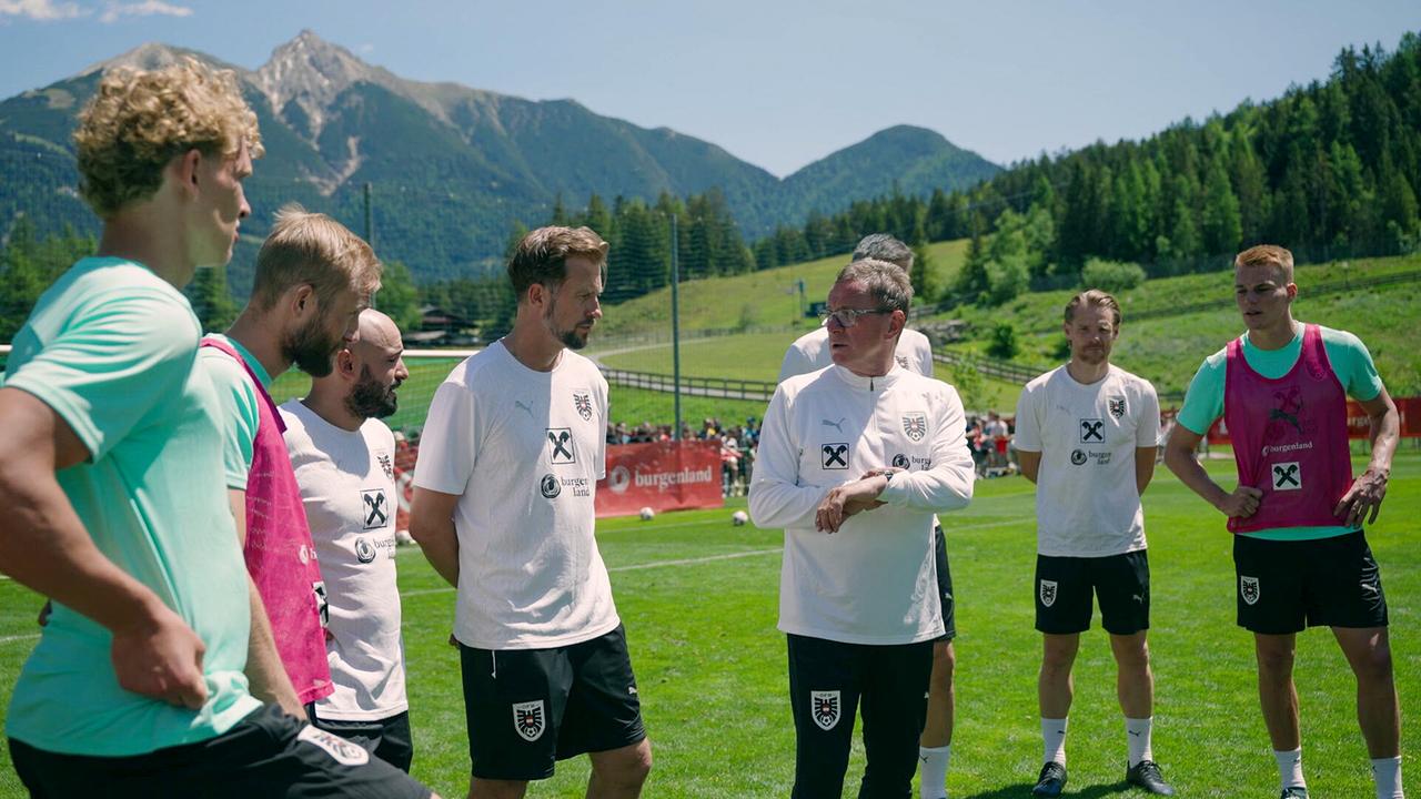 Leopold Querfeld, Konrad Laimer, Onur Cinel, Lars Kornetka und Philipp Lienhart stehen bei einem Trainingslager um Teamchef Ralf Rangnick  auf einem grünen Trainingsplatz in alpiner Umgebung zusammen.