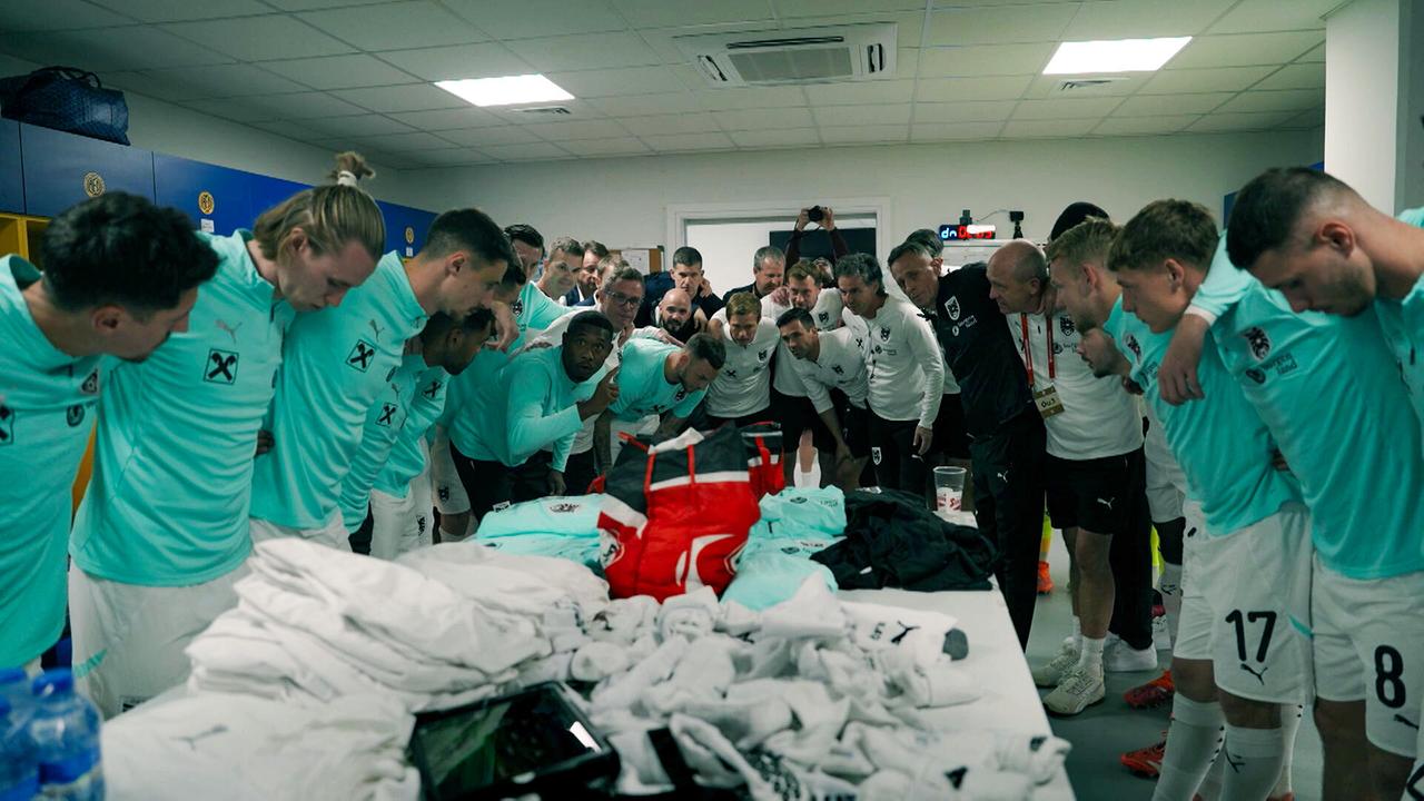 Die ÖFB-Mannschaft beugt sich gemeinsam über einen Tisch in der Kabine zu einem Teamritual.