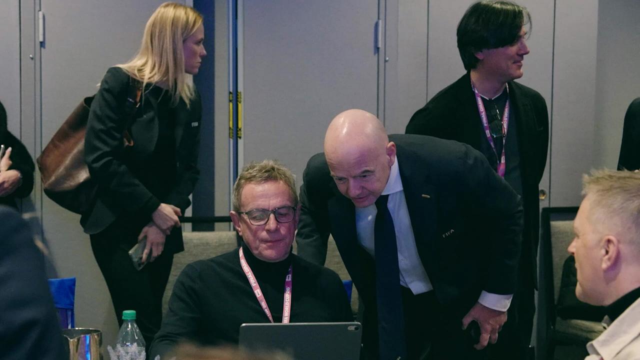 ÖFB-Teamchef Ralf Rangnick und FIFA-Präsident Gianni Infantino schauen auf ein Tablet in einem Konferenzraum umgeben von weiteren Menschen.