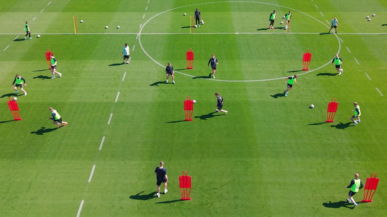 Mannschaftstraining am Fußballplatz mit aufgestellten Trainingsdummies in Marbella