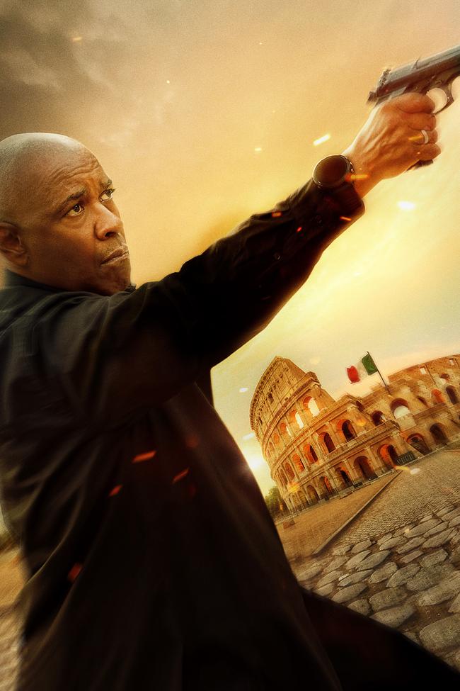 © ORF/Sony Pictures Denzel Washington als Robert McCall in dunkler Kleidung und zielt mit einer Pistole, im Hintergrund ist ein Amphitheater mit italienischer Flagge zu sehen