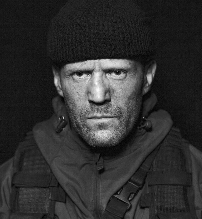 Schwarz-weiß-Porträt von Jason Statham als Christmas - mit Jacke, dunkler Haube und Drei-Tage-Bart