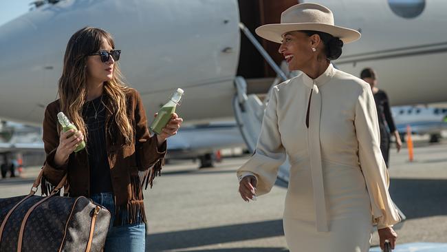 Dakota Johnson als Assistentin Maggie Sherwoode von Tracee Ellis Ross als Pop-Star Grace Davis, vor dem Privatjet hält sie zwei Flaschen mit grünen Getränken bereit