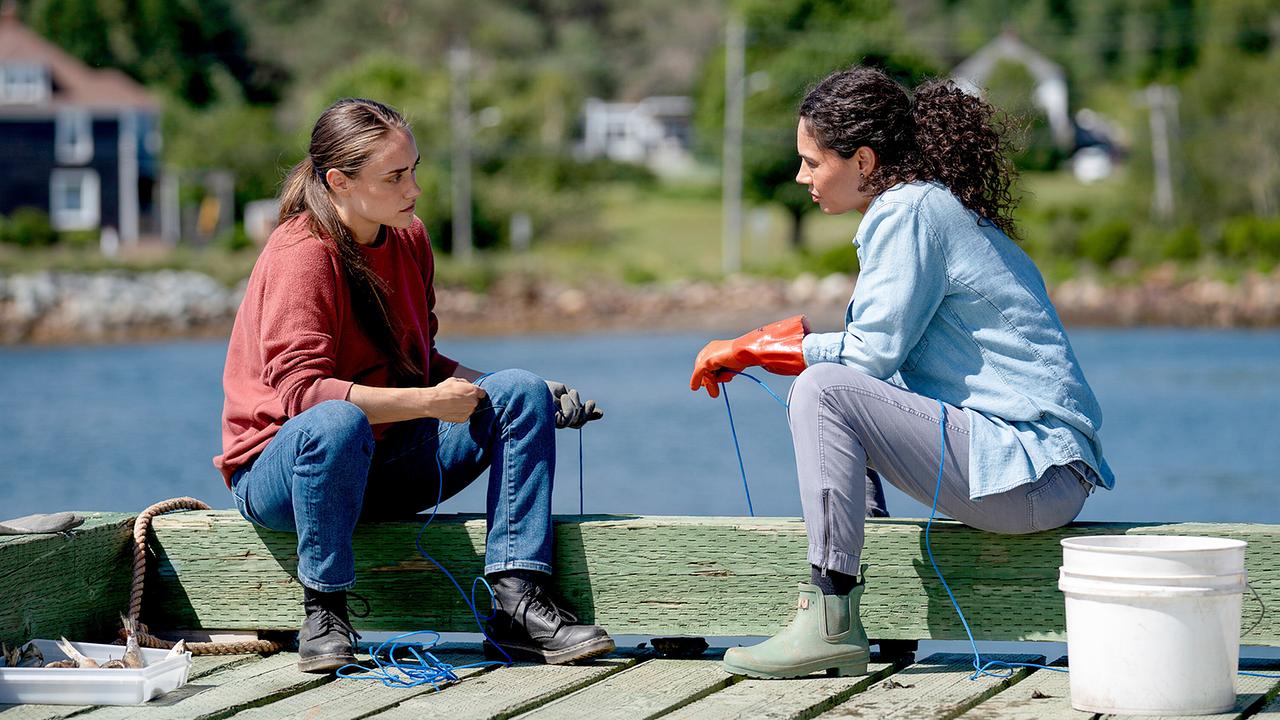 © ORF/Universal/USA Network/Michael Tompkins Percy Muldoon und Emily 'Em' Castillo unterhalten sich bei der Arbeit am Pier miteinander