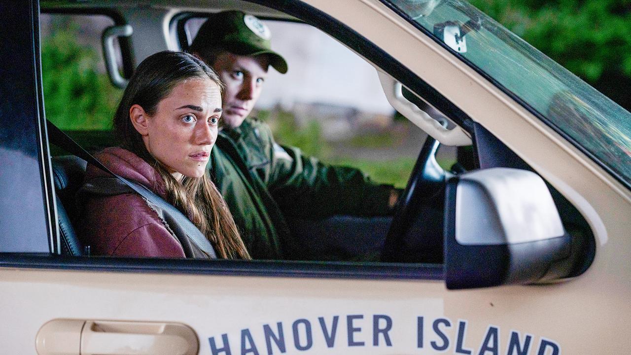 © ORF/Universal/USA Network/Michael Tompkins Percy Muldoon sitzt am Beifahrersitz, neben ihr Officer Josh Moore am Steuer des stehenden Autos, beide blicken beobachtend in dieselbe Richtung