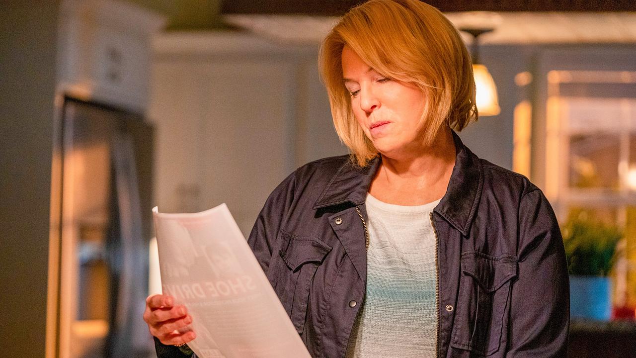 Renée Zellweger steht als Pam Hupp in ihrem Wohnzimmer und blickt auf einen Folder, den sie in der Hand hält