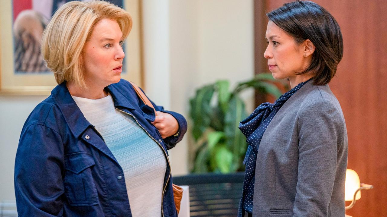 Pam Hupp in hellem Pulli und blauer Jacke trifft Tina in blauer Bluse und grauer Strickjacke in einem Büro und blickt erstaunt