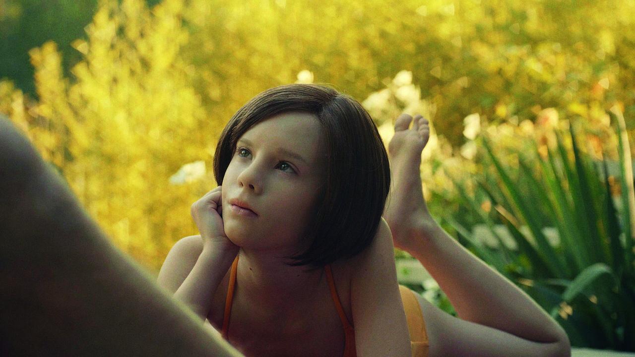 Lena Watson im Badeanzug  liegt auf dem Bauch im Garten