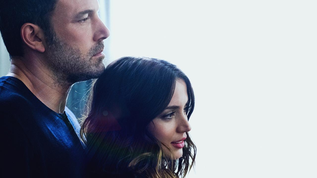 Ben Affleck steht als Victor hinter Ana de Armas als Melinda, beide blicken gedankenverloren durch eine große Fensterscheibe