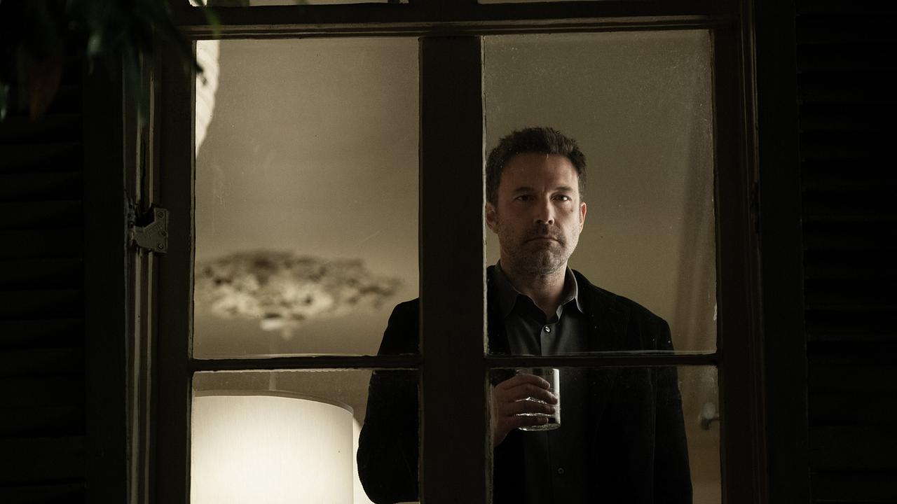 Ben Affleck blickt als Victor aus dem hell beleuchteten Zimmer durch die Scheibe in die dunkle Nacht, er hält ein Whisky-Glas in der Hand
