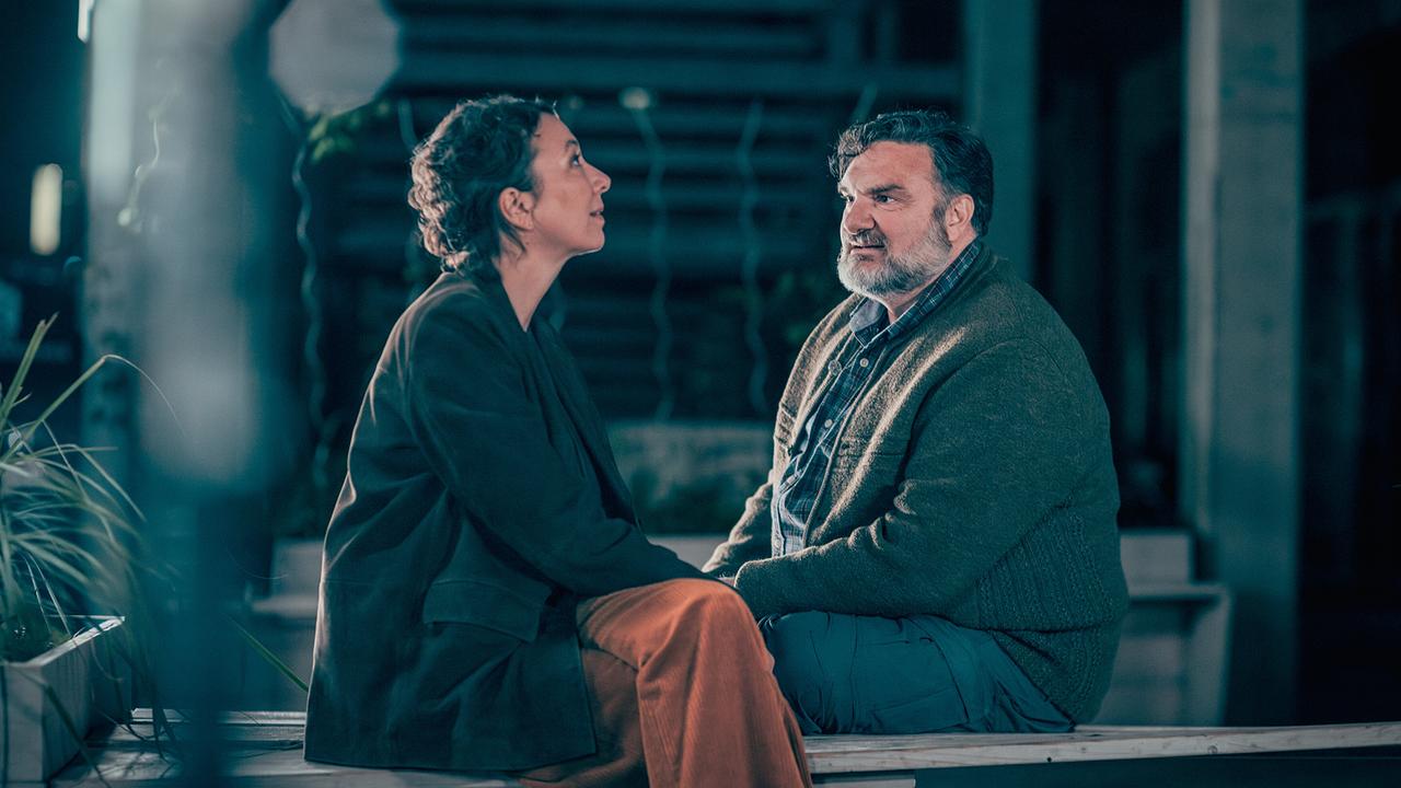 © ORF/Rundfilm/Nikolett Kustos Ursula Strauss als Fanny Gruber im Gespräch mit Martin Leutgeb als Peter Koydl, die beiden sitzen nachts auf einer Holzbank auf einer Terrasse und unterhalten sich miteinander