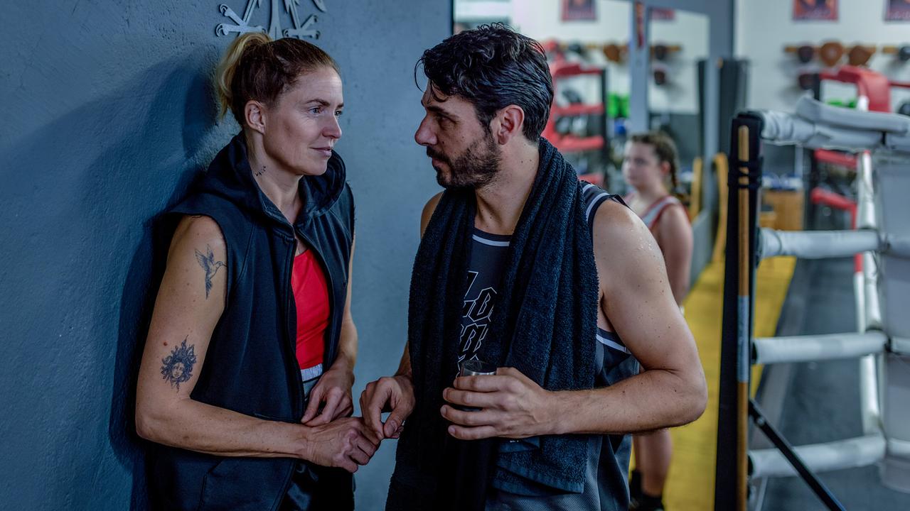 Lisa Kuen lehnt erschöpft an eine Wand nach einer Trainingseinheit im Boxstudio, ihr gegenüber steht Dolce.