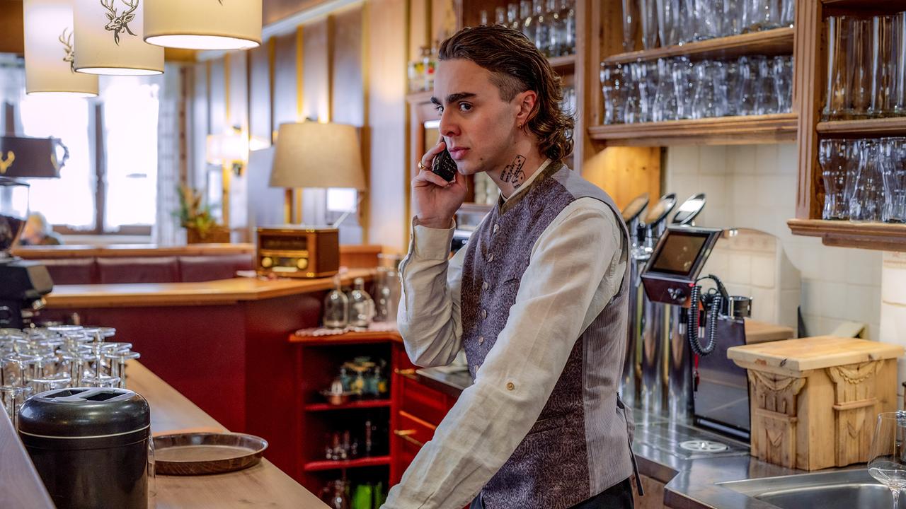 Marco Relli telefoniert hinter einer Bar in einem traditionell eingerichteten Lokal.