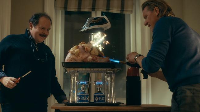 Thomas Mraz und Gery Seidl erhitzen im Film "Aufputzt is’" einen großen Braten auf improvisierte Weise mit Gasbrennern und einem darüber befestigten Bügeleisen.