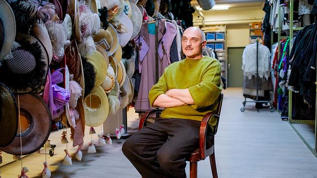 © ORF/AÖF Regisseur Markus Schleinzer sitzt in einem Kostümfundus zwischen Kleiderständern und zahlreichen Hüten.