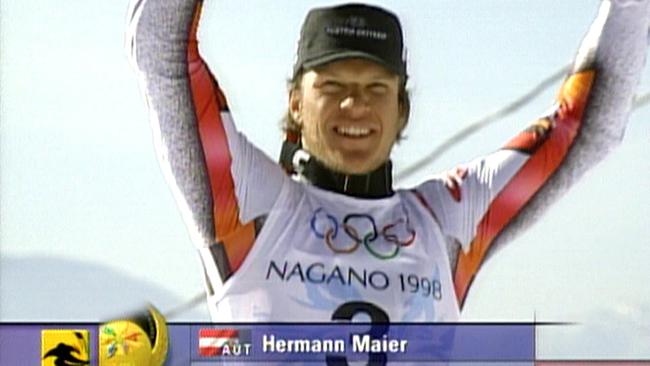 © ORF Hermann Maier im rot‑weißen Anorak jubelt auf einem Podium bei den Olympischen Winterspielen in Nagano 1998 über eine Goldmedaille.