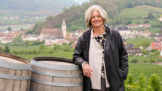 Sibylla Zech steht neben Weinfässern in den Weinbergen mit Blick auf die Donau und schildert die Platznot, die dazugehörige Raumplanung in der Wachau und die Bedeutung des UNESCO-Titels