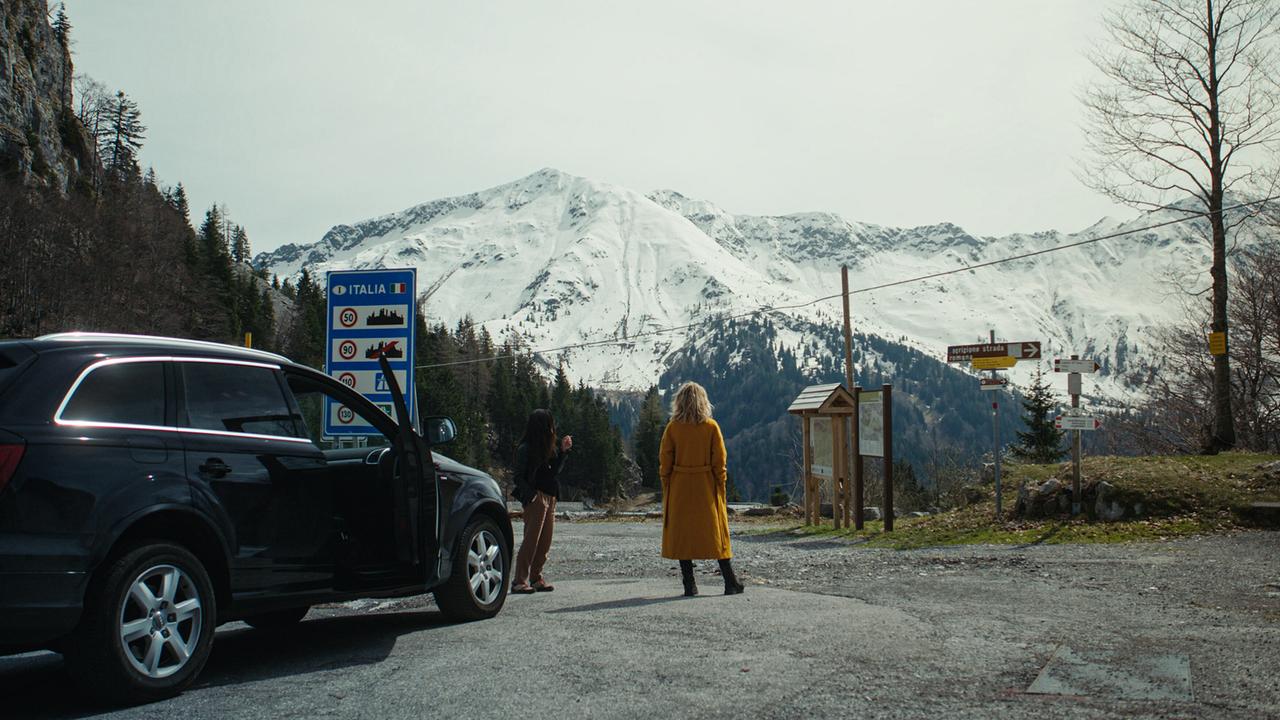© ORF/One Gate/Arte/beetz brothers film production/Nikolaus von Schlebrügge Zwei Frauen machen am Grenzpass nach Italien Pause, vor ihrem Auto stehend bewundern sie das verschneite Bergpanorama