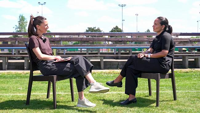 © ORF Karoline Rath-Zobernig und Irene Fuhrmann sitzen im Freien auf Stühlen gegenüber und führen auf einer Wiese vor leeren Tribünen ein Gespräch.