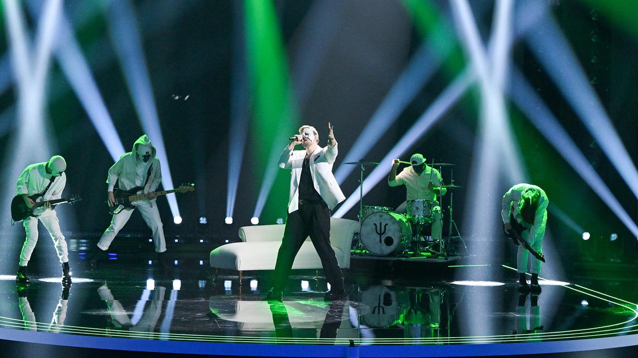 Die Band Frevd in weißen Outfits spielt unter grün-weißem Licht, mit einem weißen Sofa als Bühnenelement in der Mitte.