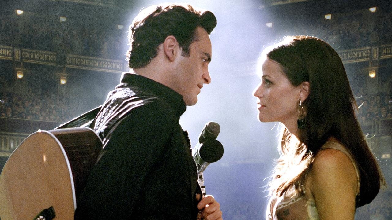 Auf der Bühne eines Konzertsaals stehen sich Johnny Cash und June Carter gegenüber und blicken sich tief in die Augen, er trägt eine Gitarre am Rücken, sie hält den Mikrofonständer